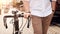 Closeup photo of young man with bicycle commuting to work