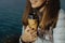 Closeup photo of Young woman in blue coat holds a thermos with h