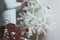 Closeup photo of young woman decorating white Christmas Tree at