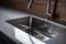 Closeup Photograph Of Shiny, Stainless Steel Kitchen Sink With Faucet, Impeccably Clean And Gleaming