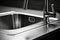 Closeup Photograph Of Shiny, Stainless Steel Kitchen Sink With Faucet, Impeccably Clean And Gleaming