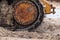 Closeup photograph of the track of an old large industrial yellow bulldozer machine weathered, rusty and worn sitting on a beach