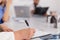 Closeup of physician senior woman writing sickness treatment on clipboard