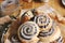 Closeup picture of a bitten delicious Poppy snail pastry with a sugar glaze on a wooden table