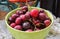 Closeup picture of a green bowl of fresh cherries