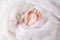 Closeup picture of newborn baby feet on white knitted plaid. Fine concept of the childhood and motherhood