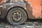 Closeup pictures of an orange old car that has been left to decay, tires become flat and rust