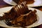 Closeup of pieces of a birthday celebration chocolate cake on a white plate