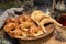 Closeup of pieces of croissant on a wooden plate with tea and herbs around it