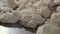 Closeup of pieces of dough lay on stainless steel working table.