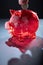 Closeup of a piggy bank against a dark background. A hand depositing a euro coin.