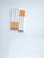 Closeup of a pile of cigarettes over white background. The tobacco can cause numerous damages to the organism