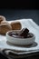 Closeup of a pile of walnut-filled chocolate confections on a small plate.