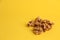 Closeup of a pile of walnuts under the lights isolated on a yellow background