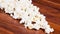 Closeup pile of white fluffy popcorn lying mixed together on wooden surface