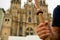 Closeup of pilgrim hand holding walking stick with scallop shell, symbol of the camino de santiago pilgrimage, in front of the