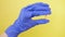 Closeup on pill capsule held in gloved hand. medical worker, doctor in lab. isolated on yellow background. 4K