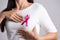 Closeup of pink badge ribbon on woman chest to support breast cancer cause. Healthcare, medicine and breast cancer awareness