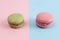 Closeup of pink and green macarons.