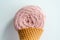 Closeup of pink macrame yarn skein in ice cream cone over a white background