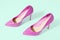 Closeup pink women patent leather shoes isolated on green background. Stilettos shoe type. Summer fashion and shopping concept.