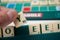 Closeup of plastic letters Y in hand on Scrabble board game