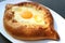 Closeup a Plate of Adjarian Khachapuri, Cheese and Egg Filled Traditional Georgian Bread