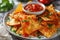 closeup of a plate of delicious crispy nachos with hot sauce