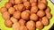 Closeup of a plate of fried brown tofu balls, vegetarian snack on spinning plate