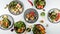 Closeup of the plates of sushi with fresh vegetables on the white table