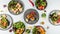 Closeup of the plates of sushi with fresh vegetables on the white table