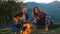 Closeup playful couple spend holiday sit bonfire. Lovers play music in mountains