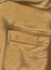 Closeup pocket. Raw sienna or ocher color cotton shirt. English style. Solid fabric texture. Casual style. Empty space for text.