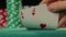 Closeup of poker player\'s hand checking cards, holding two aces, chance to win