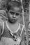 Closeup of a poor staring hungry orphan boy in a refugee camp with sad expression.