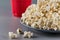 Closeup popcorn on the background of red plastic cups with fizzy drink.