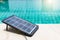 Closeup Portable solar cell panel on clear swimming pool background, clean energy concept