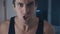 Closeup portrait of aggressive man in wife-beater screaming and threatening violence at home