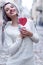 Closeup portrait amazing girl in the white warm woolen sweater with gray silver hair with red and white lollipop