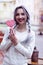 Closeup portrait amazing girl in the white warm woolen sweater with gray silver hair with red and white lollipop