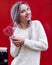 Closeup portrait amazing girl in the white warm woolen sweater with gray silver hair with red and white lollipop