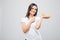 Closeup portrait of attractive caucasian smiling woman brunette pointed on bananas on white background. Healthy food conc