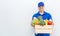 Closeup portrait of beautiful caucasian delivery man in blue uniform holding wood basket of grocery fresh vegetables food.