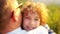 Closeup portrait of a beautiful curly-haired boy who embraces his father. Children`s Day. Father`s Day