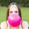 Closeup portrait of beautiful girl inflating balloon, outdoor.