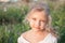 Closeup portrait of a beautiful little girl outdoors in summer.