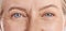 Closeup portrait of a beautiful older womans blue eyes. Healthy and natural mature woman with deep lines and crows feet