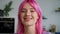 Closeup portrait of beautiful pink haired young woman flirting indoors