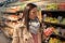 Closeup portrait of beautiful and pretty young woman picking up and choosing  fruit and vegetables in grocery store. The concept
