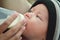 Closeup portrait of beautifull baby boy drinking milk from his mother from feeding bottle